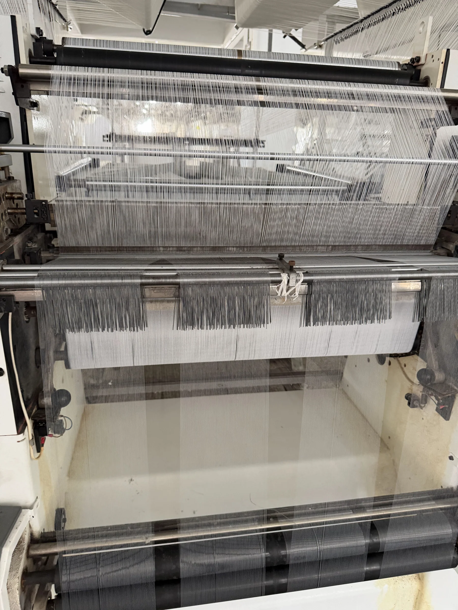 Close view of warp yarn passing through textile weaving machinery