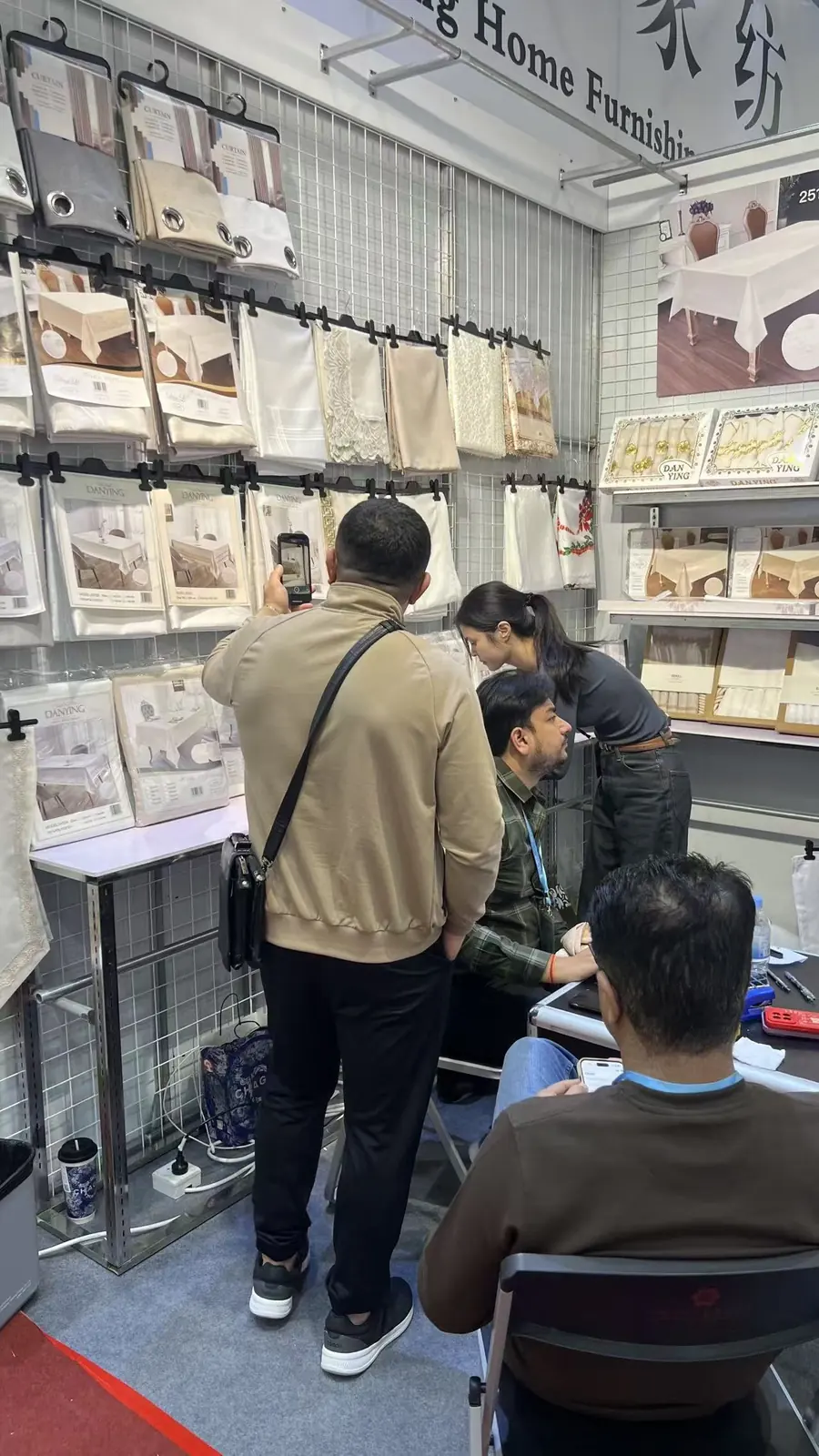 Visitors discussing home textile samples with the Danli team
