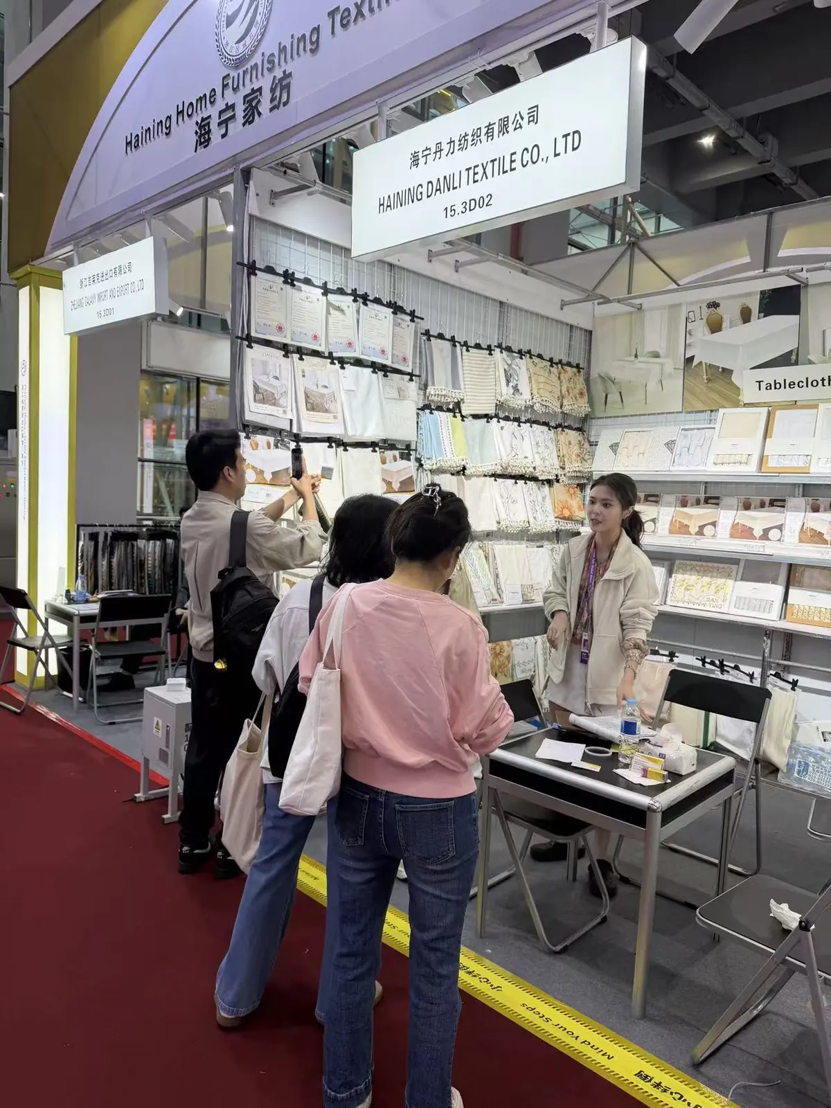 Visitors discussing home textile products at the Danli booth
